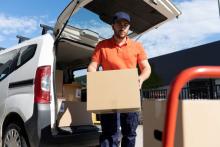 Un repartidor de paquetes lleva una caja